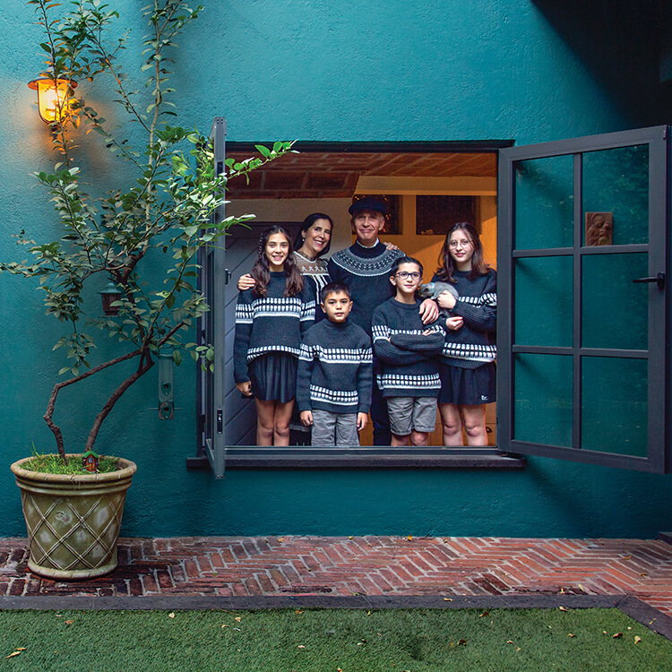 Familia reunida en una ventana de su casa, reflejando la importancia del equilibrio entre vida familiar y vida profesional.