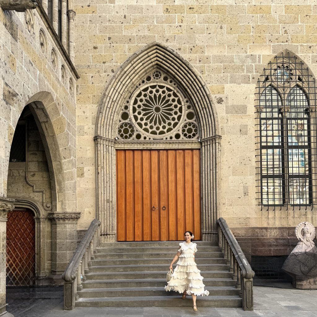 Mariangel Coghlan frente a una puerta gótica de arquitectura histórica durante un viaje de inspiración arquitectónica